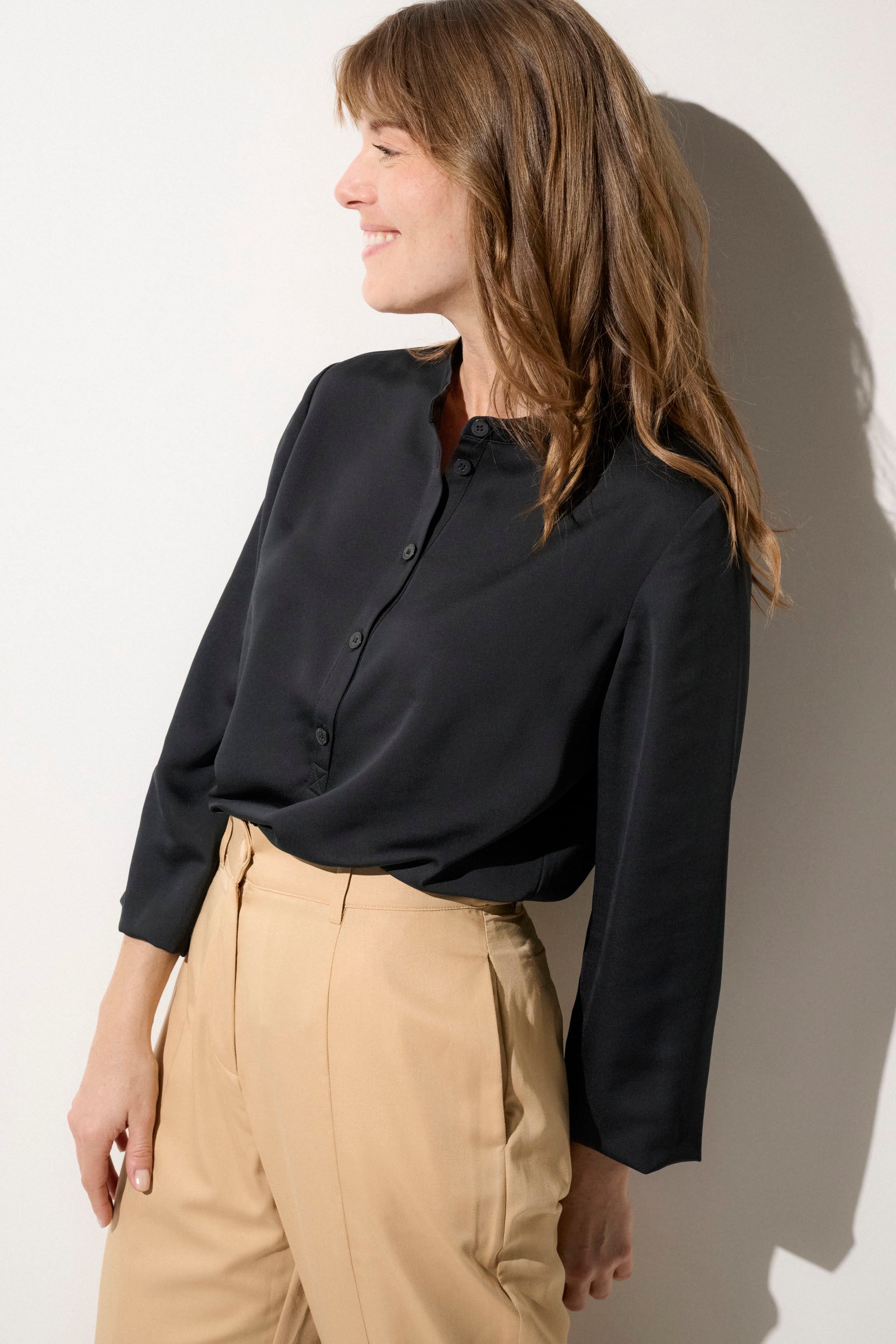 Blouse anti-UV noire élégante pour femme, manches longues et légère, idéale pour la protection solaire au quotidien.