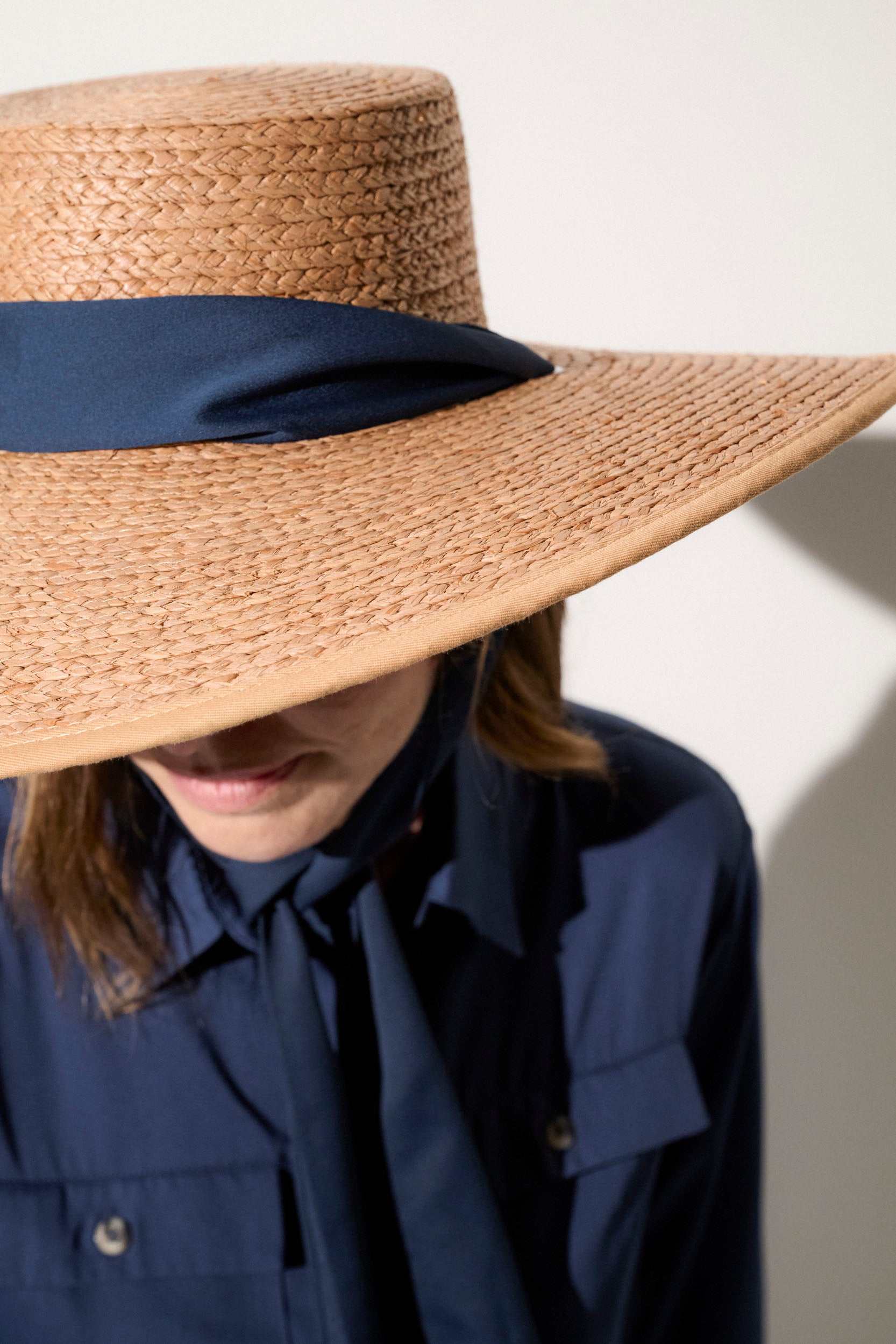 Chapeau anti-UV en paille avec ruban bleu, offrant une protection solaire optimale pour femme lors des journées ensoleillées.