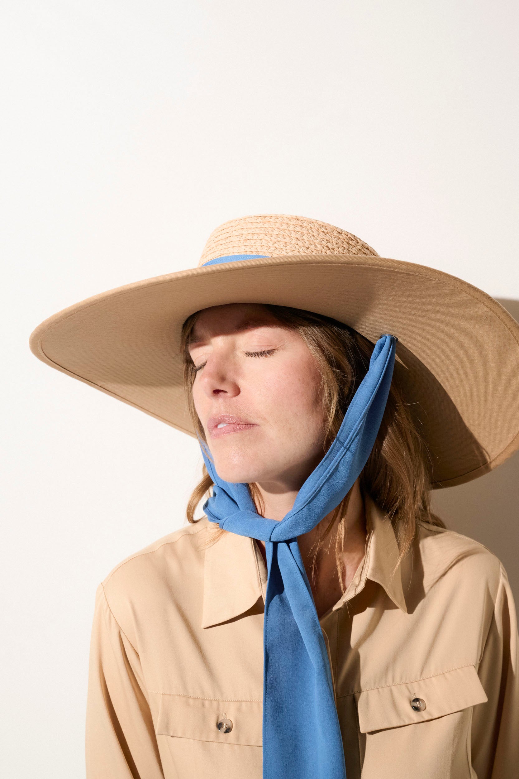 Chapeau anti-UV UPF 50+ beige pour femme, avec foulard bleu, idéal pour se protéger du soleil en extérieur.