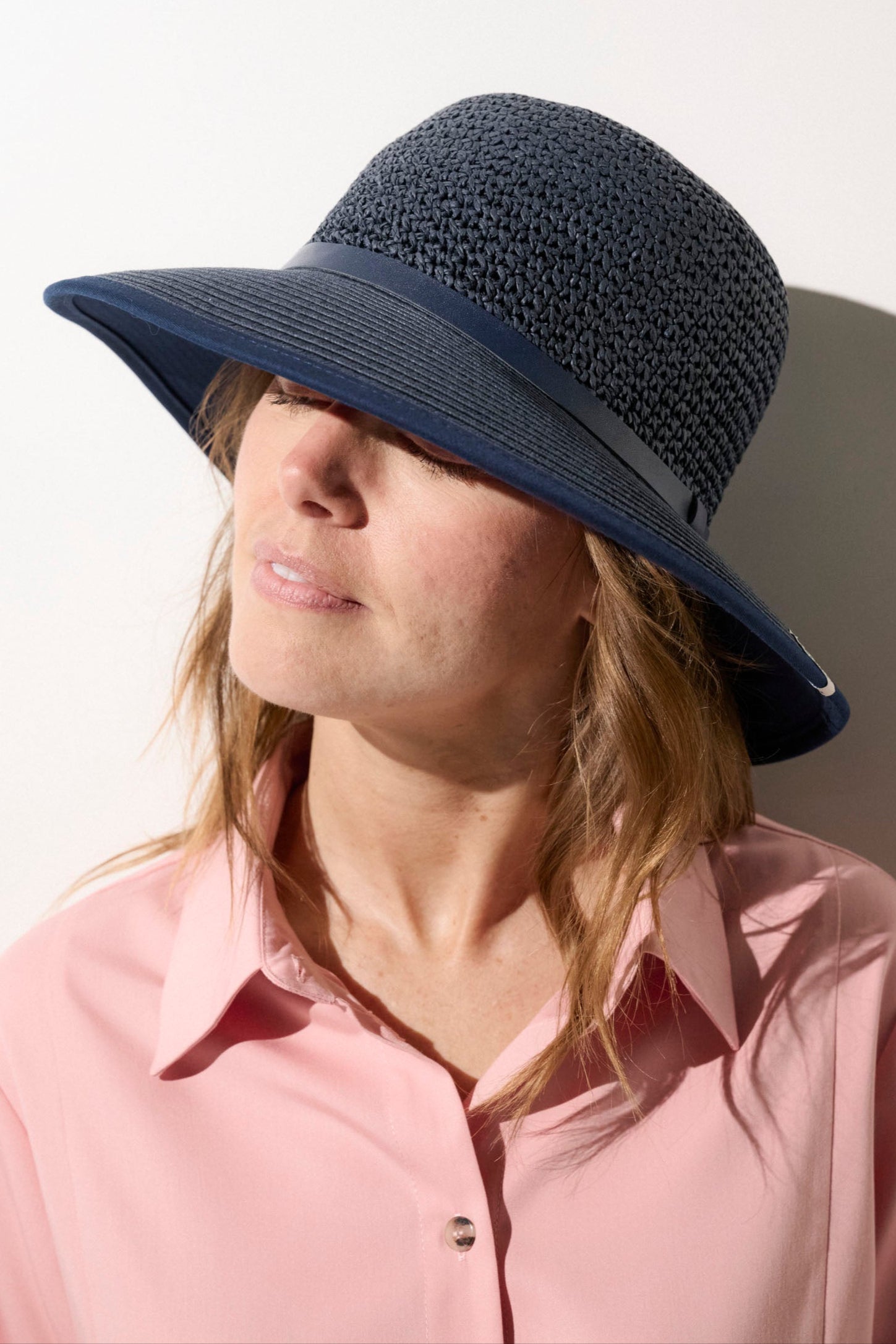 Chapeau anti-UV bleu marine UPF50+ pour femme, idéal pour une protection solaire lors des sorties estivales.