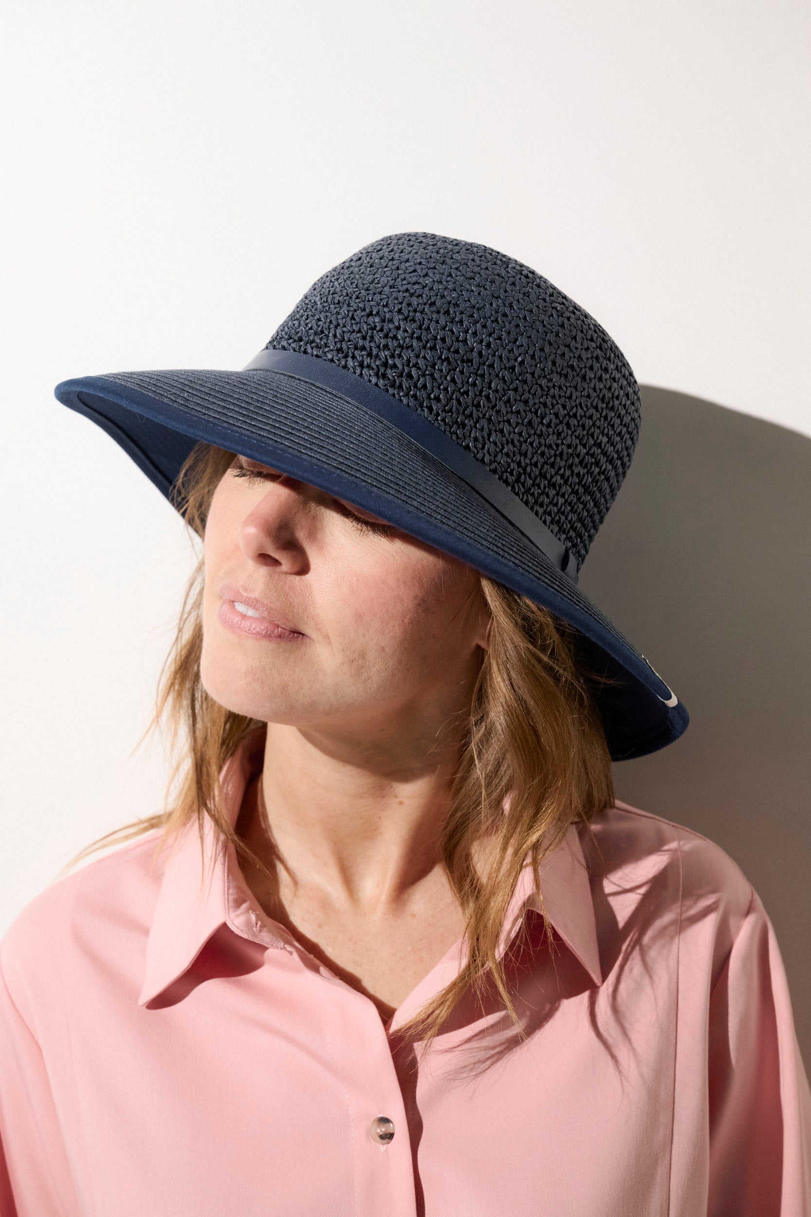 Chapeau anti-UV bleu marine UPF50+ pour femme, idéal pour une protection solaire lors des sorties estivales.