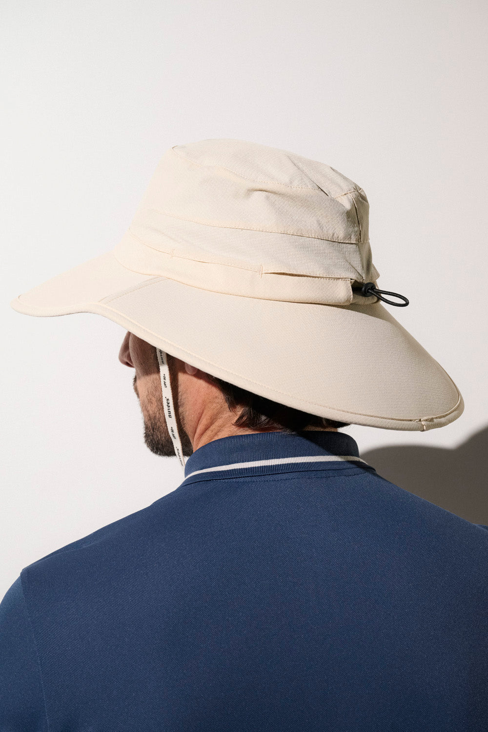 Chapeau anti-UV beige pour homme avec protection UPF50+, idéal pour le golf et les activités de plein air.