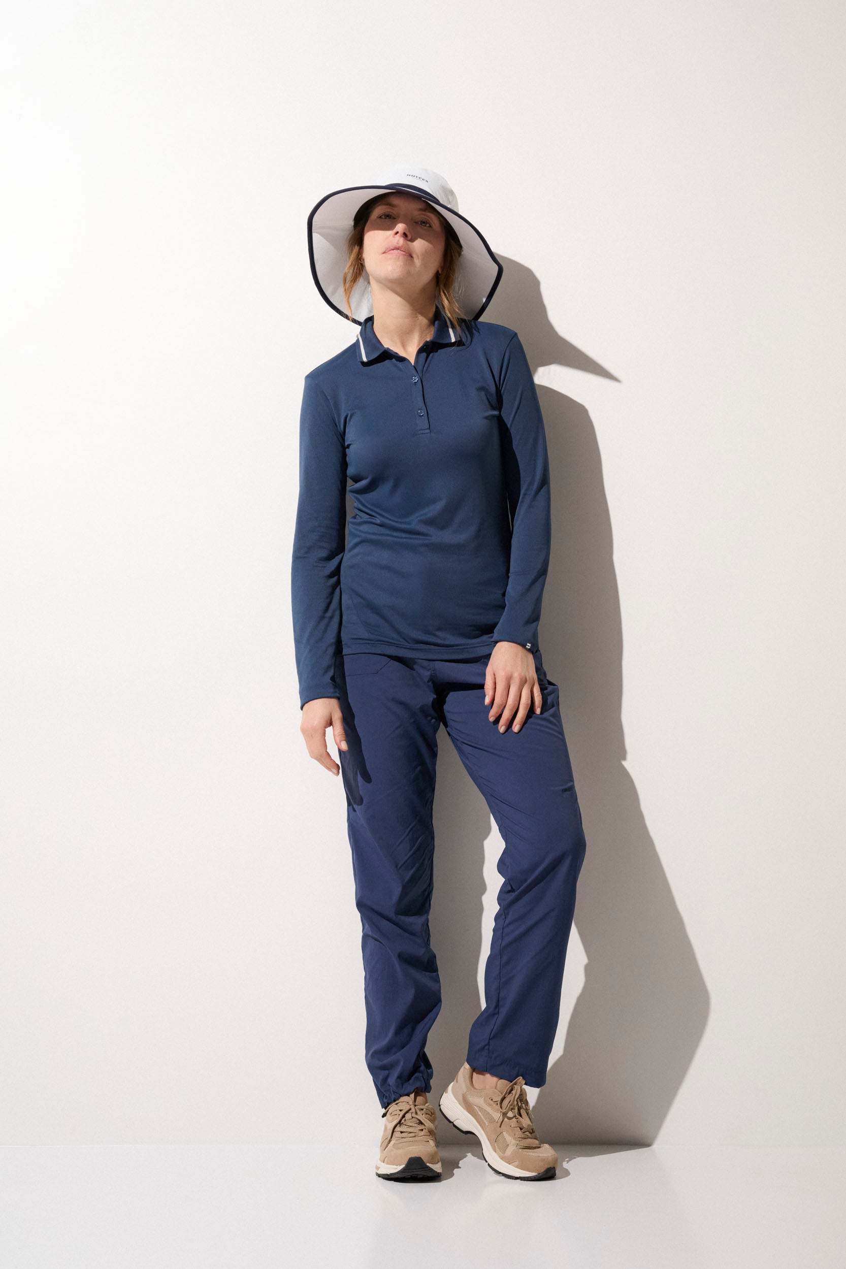 Femme en tenue de sport anti-UV, portant un chapeau UPF 50+, idéale pour une journée en extérieur.