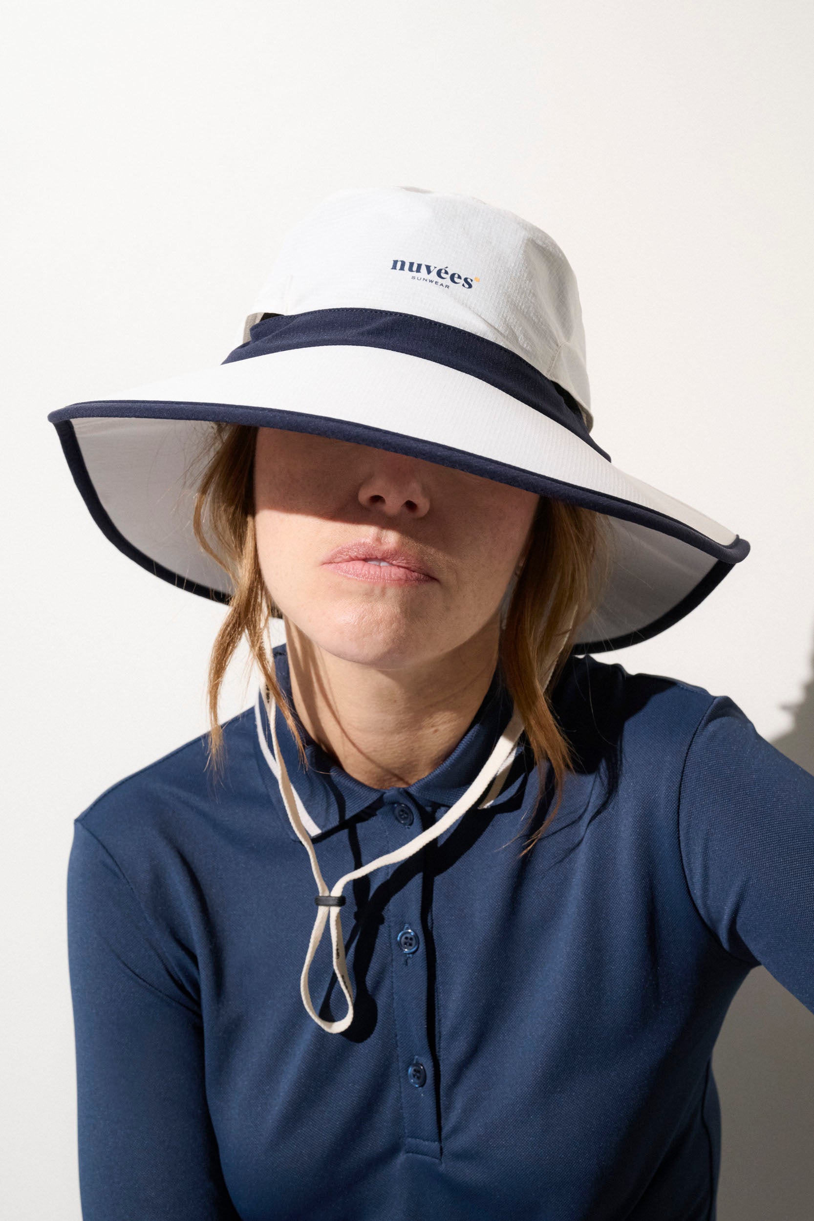 Chapeau anti-UV blanc et bleu UPF50+ pour femme, léger et élégant, adapté au golf et aux sports de plein air.