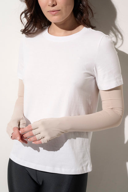 Femme portant un t-shirt blanc et des mitaines anti-UV UPF50+, idéale pour une protection solaire quotidienne.