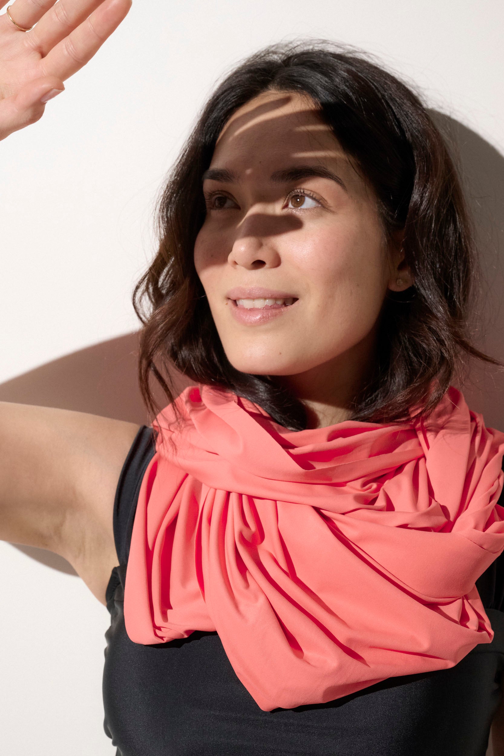 Femme portant un foulard anti-UV rose, léger et respirant, idéale pour une protection solaire quotidienne avec UPF 50+.