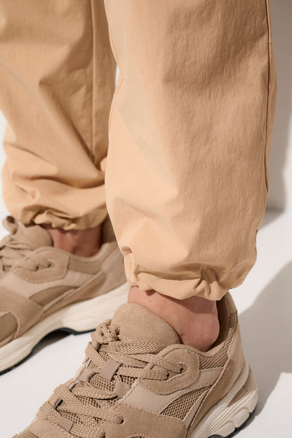 Pantalon anti-UV beige pour homme, léger et respirant, parfait pour les activités de plein air et la protection solaire.