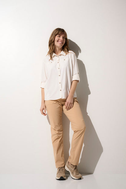 Femme portant un pantalon anti-UV beige UPF50+, léger et confortable pour des activités de plein air.