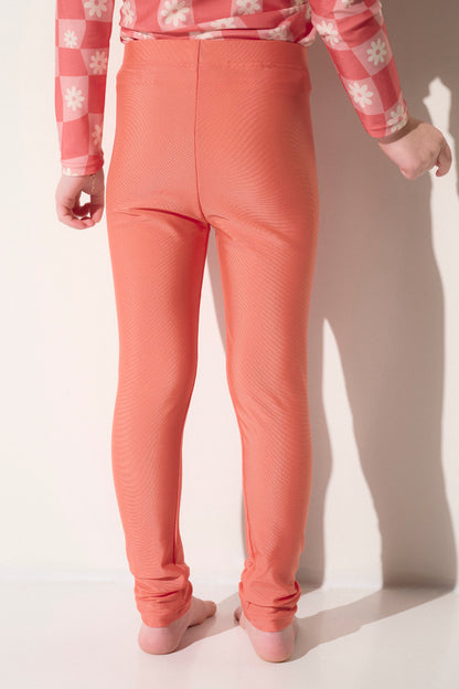 Legging de bain anti-UV pour fille, couleur corail, UPF50+, idéal pour la plage et les jeux aquatiques.