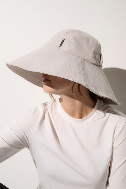 Chapeau anti-UV beige UPF50+ pour femme, idéal pour se protéger du soleil lors d'activités en extérieur.