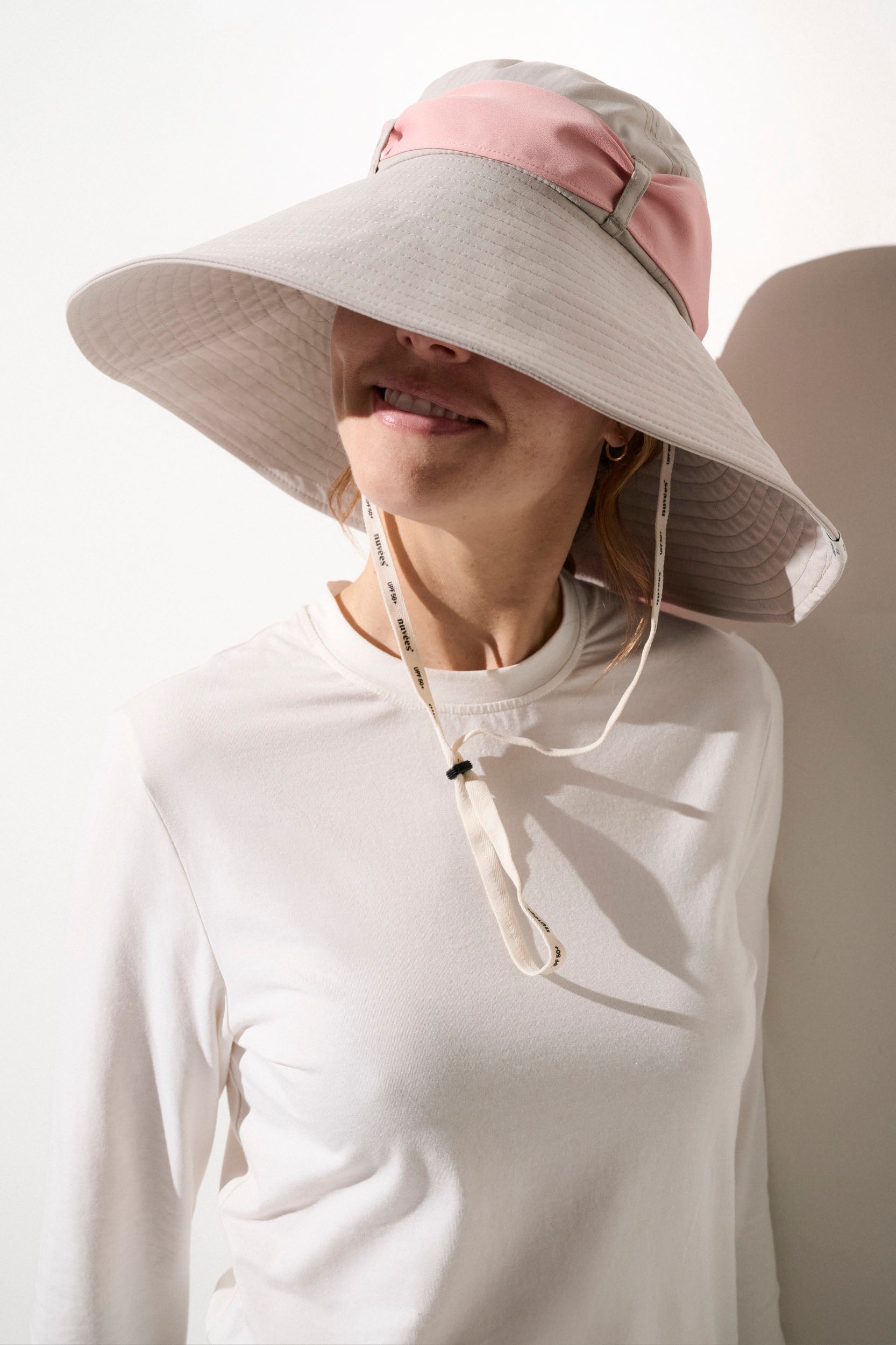 Chapeau anti-UV beige et rose UPF50+ pour femme, idéal pour activités en extérieur et protection solaire.