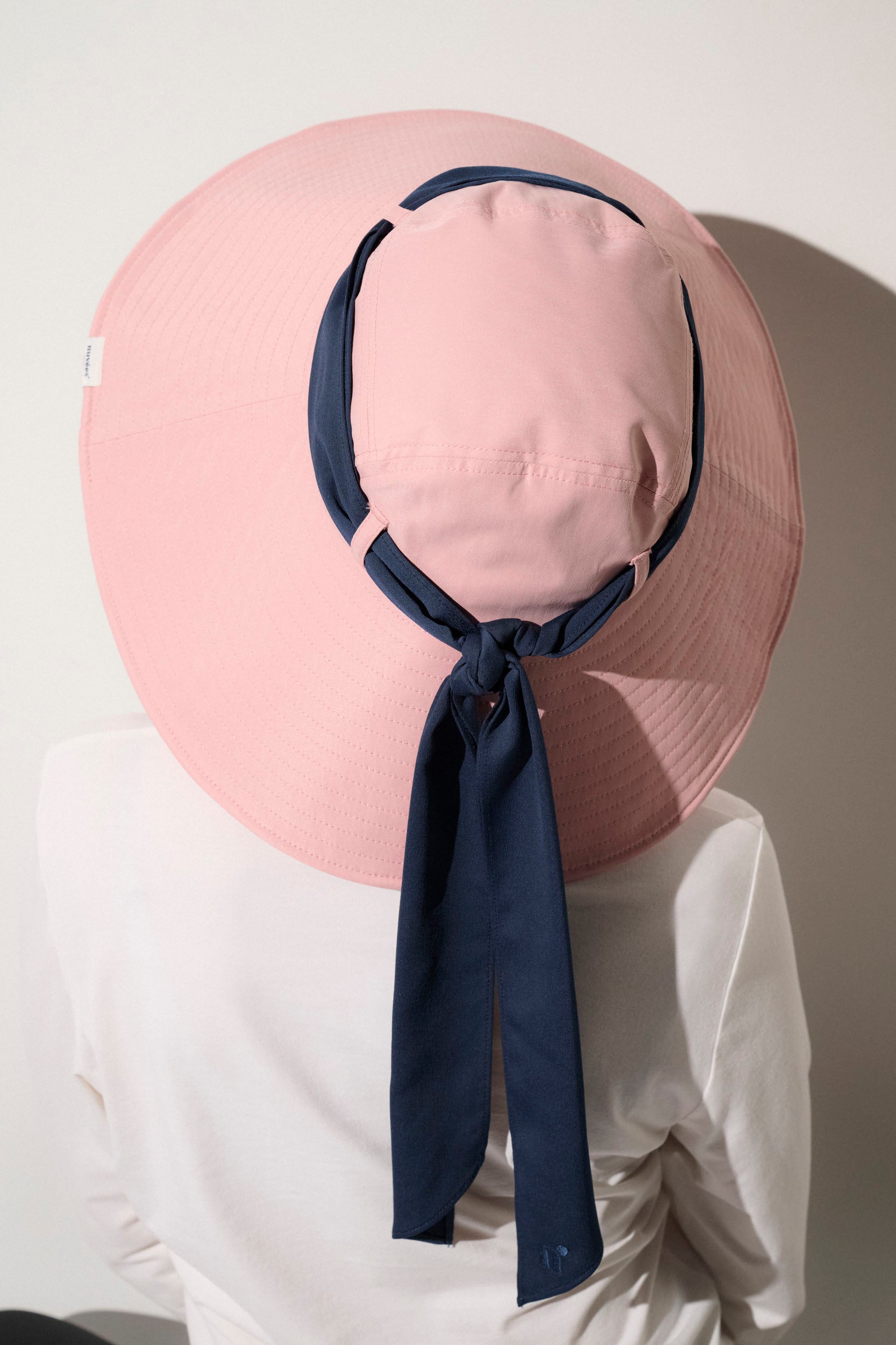 Chapeau anti-UV rose avec un ruban bleu, UPF 50+, idéal pour femme lors d'activités extérieures.