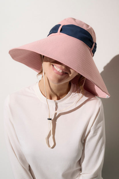 Chapeau anti-UV rose et bleu pour femme, large bord UPF 50+, idéal pour se protéger du soleil lors d'activités extérieures.