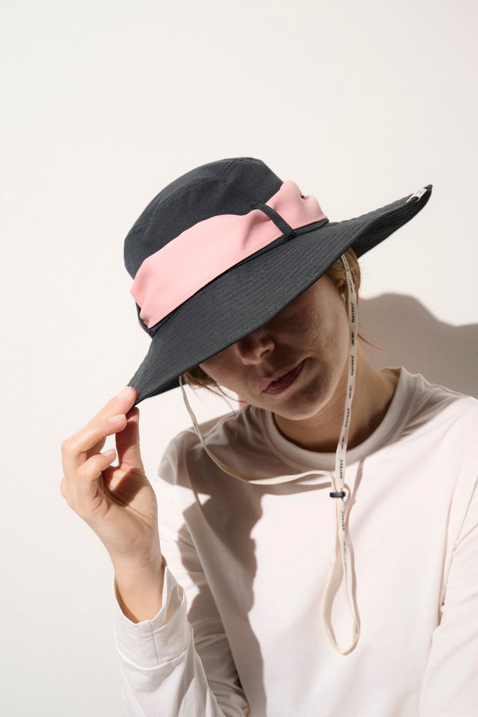 Chapeau anti-UV UPF50+ noir et rose pour femme, léger et pratique, idéal pour une protection solaire quotidienne.