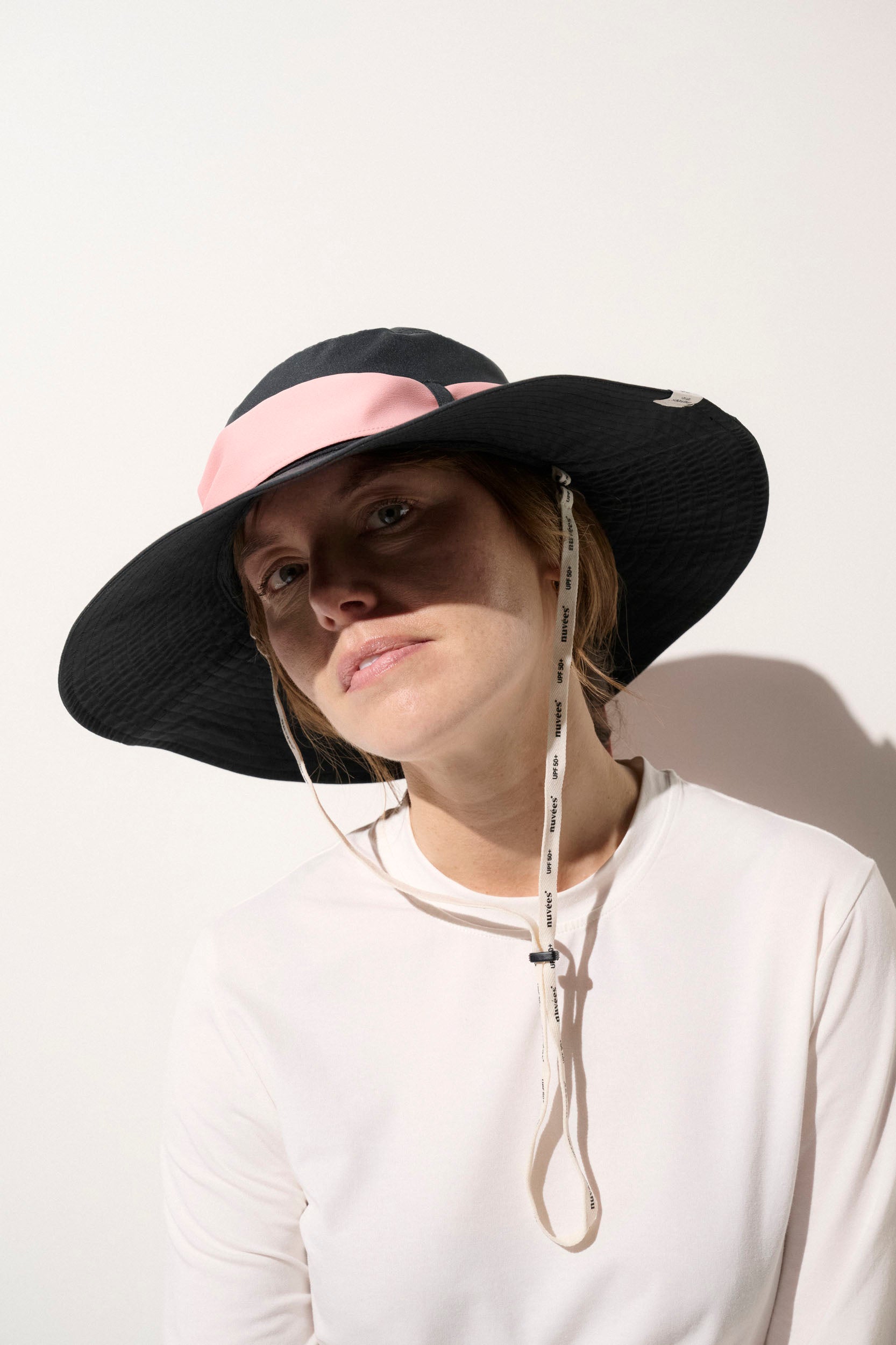 Chapeau anti-UV noir et rose UPF50+ pour femme, léger et pratique, idéal pour des activités en extérieur.