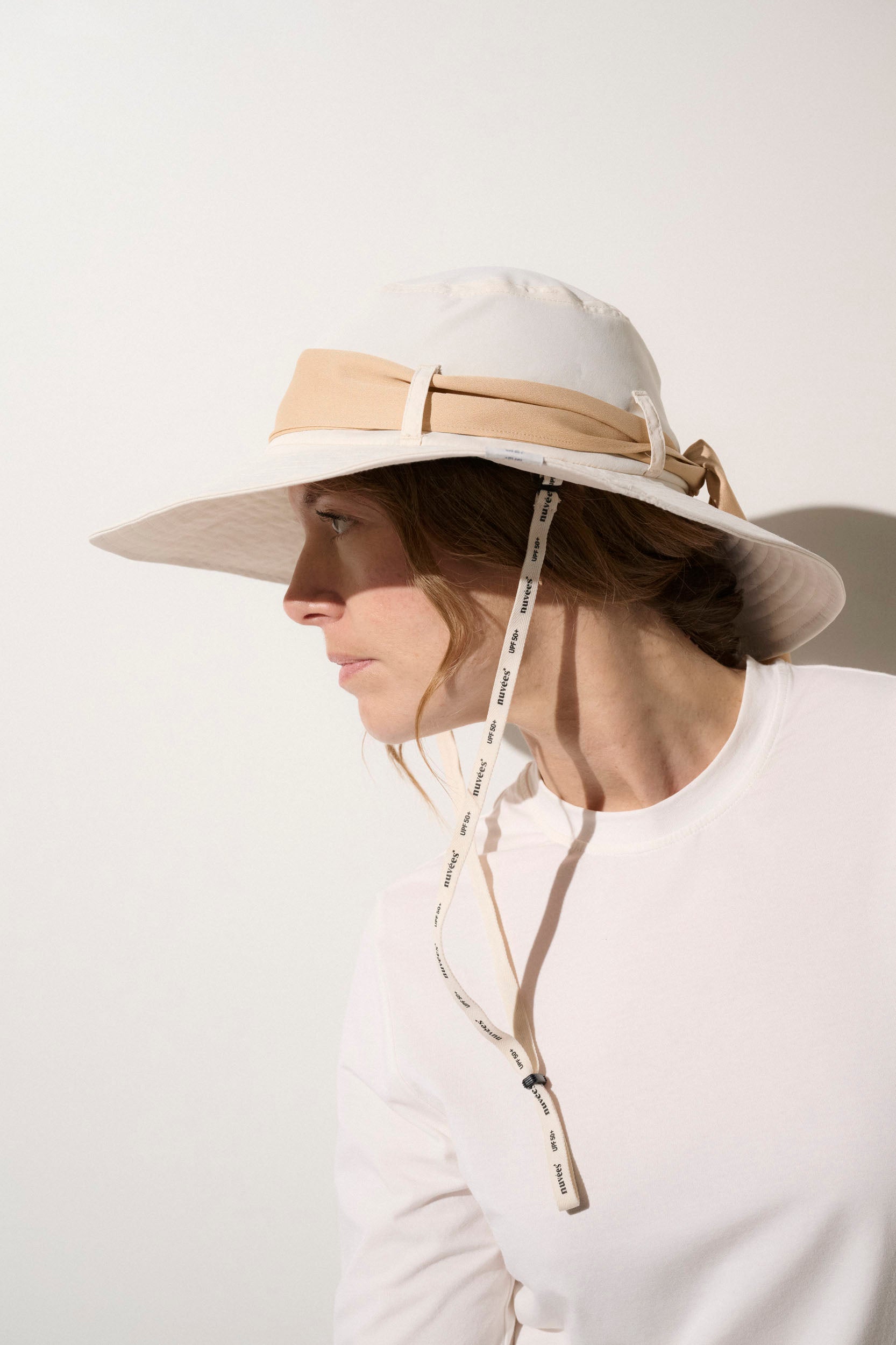 Chapeau anti-UV beige pour femme, léger et élégant, offrant une protection solaire UPF 50+ lors d'activités extérieures.