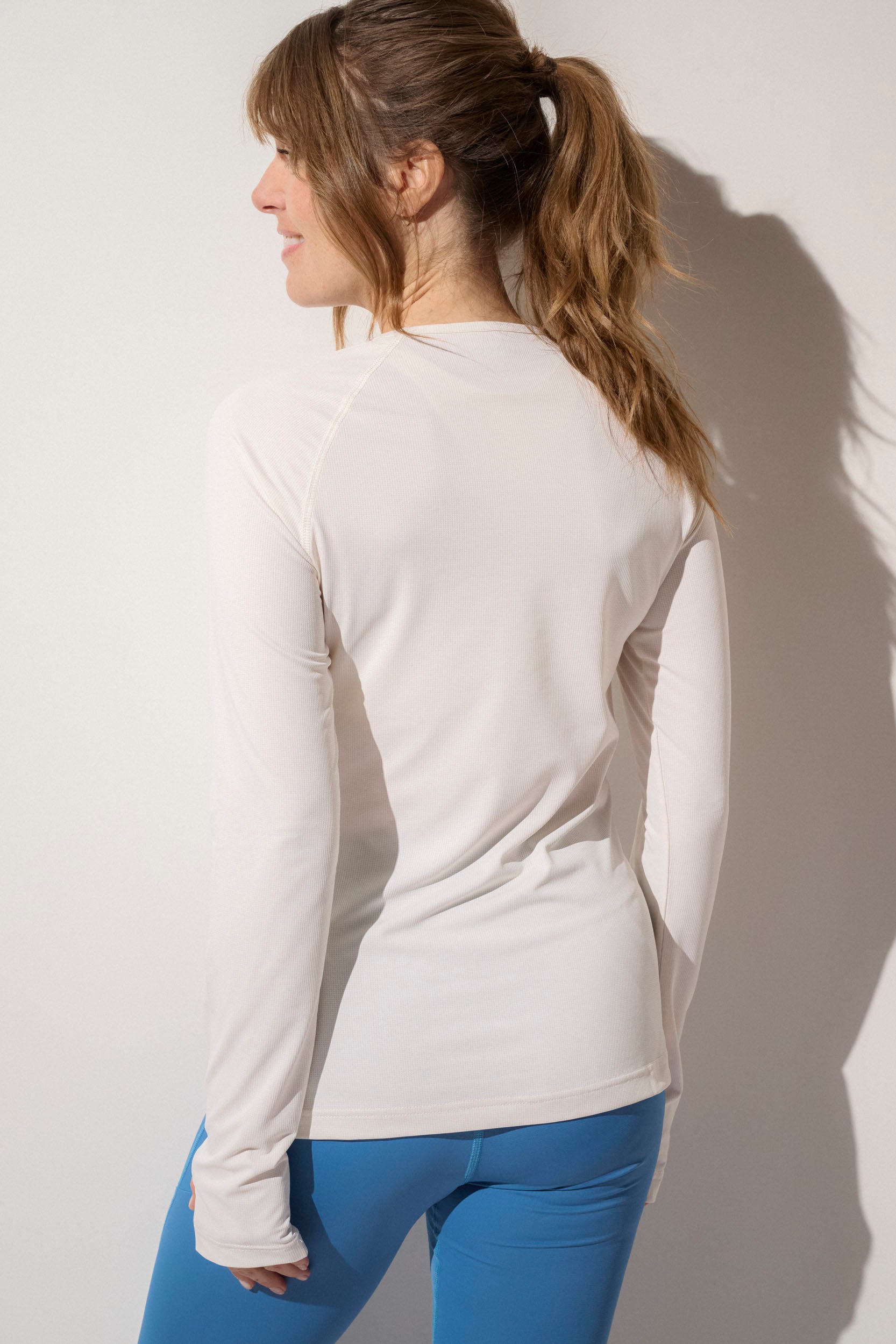 T-shirt anti-UV femme en White Pearl, tissu léger et respirant, idéal pour les activités sportives extérieures.