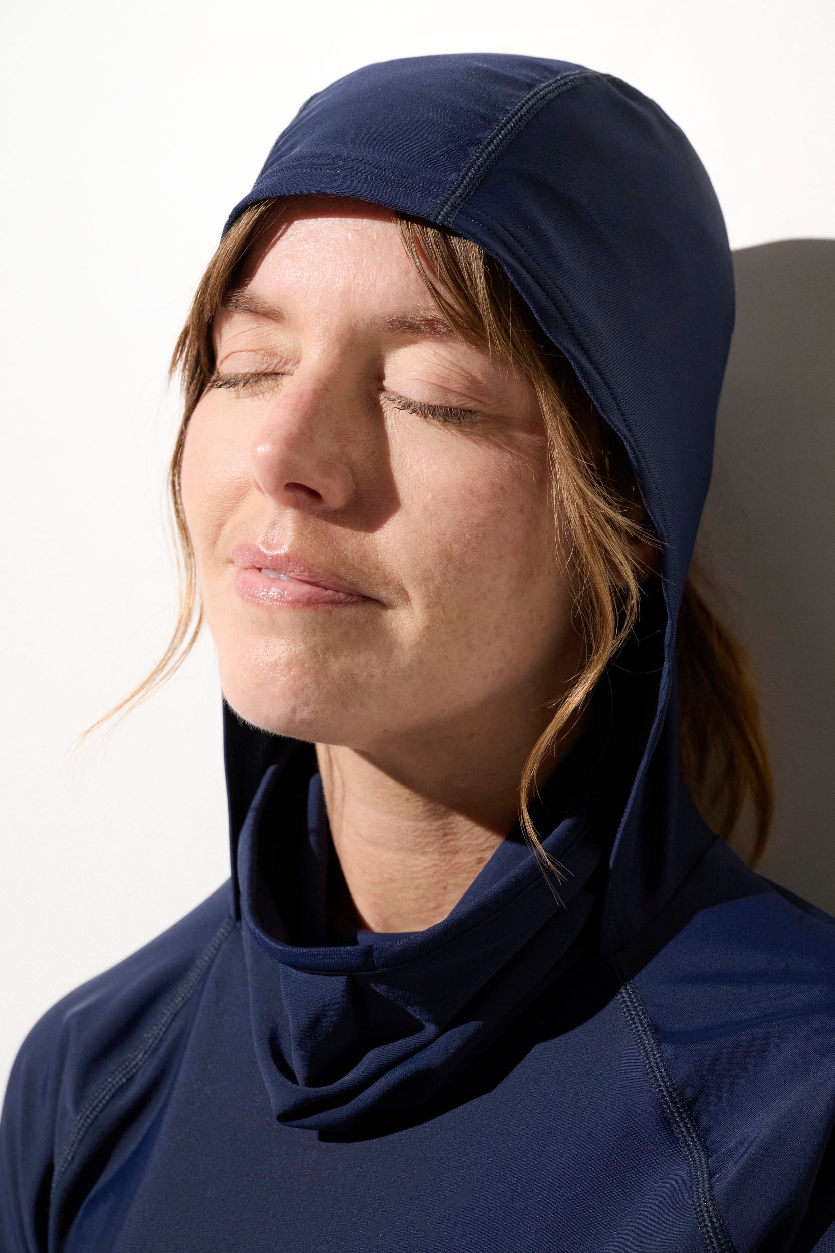 Femme portant un sweat-shirt de bain anti-UV bleu, protection solaire optimale avec capuche. UPF 50+.