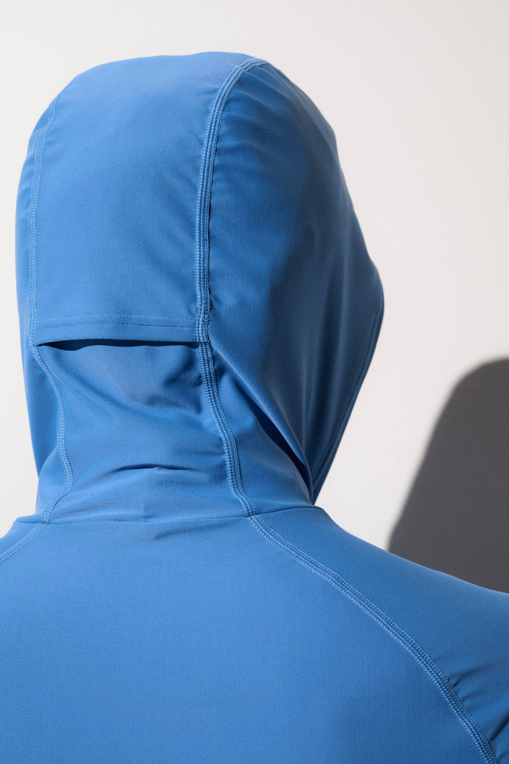 Sweat-shirt de bain anti-UV bleu avec capuche, tissu léger, idéal pour la protection solaire lors des activités aquatiques.