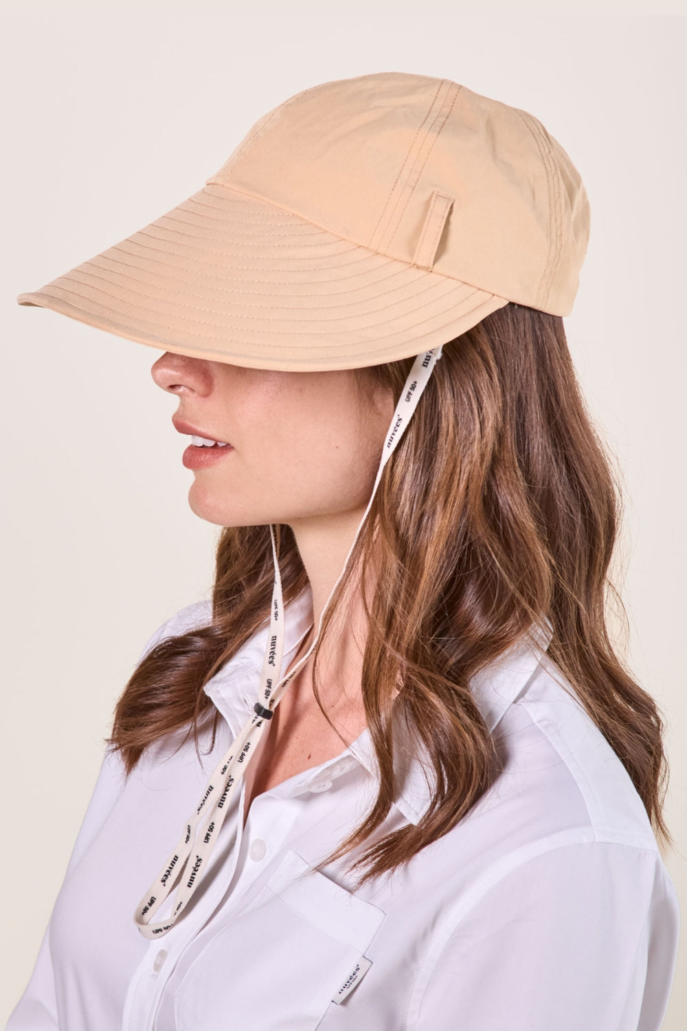 Casquette anti-UV beige UPF50+ pour femme, idéale pour se protéger du soleil lors d'activités en plein air.