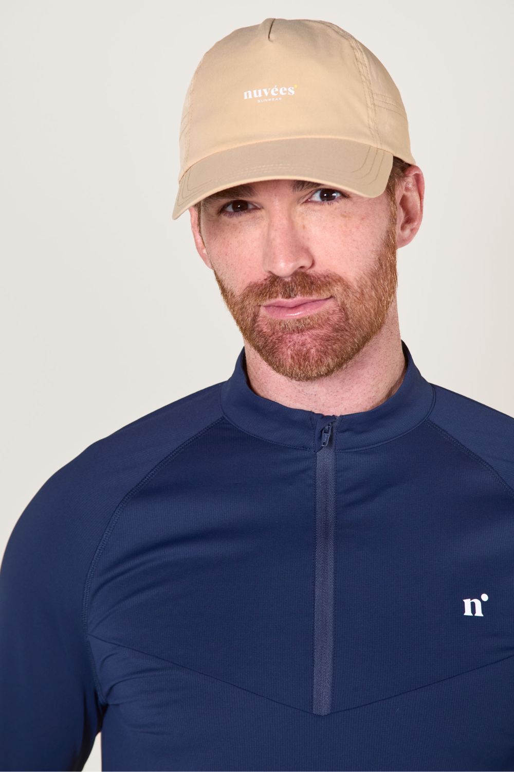 Casquette anti-UV beige portée par un homme, idéale pour le sport et les activités en plein air.