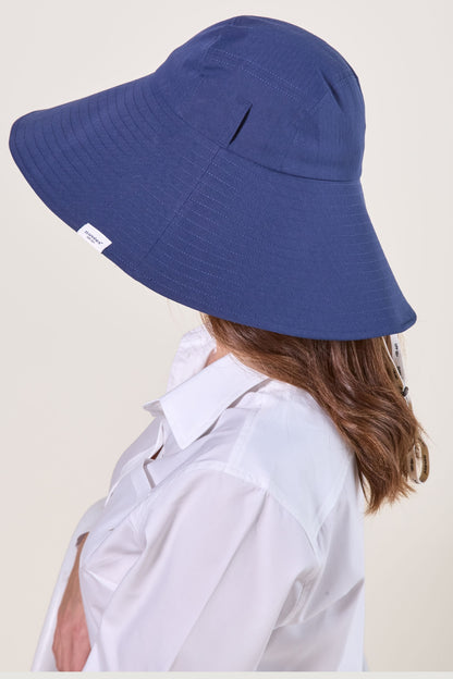 Chapeau anti-UV bleu pour femme, avec large bord pour une protection solaire élégante et confortable.