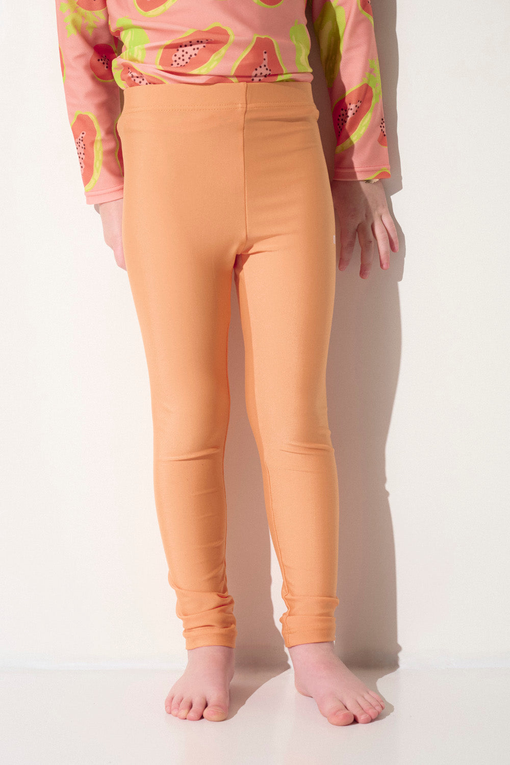 Legging de bain anti-UV orange pour fille, léger et extensible, certifié UPF 50+ pour une protection solaire optimale.