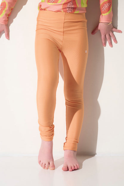 Legging de bain anti-UV orange pour enfant, léger et extensible, certifié UPF 50+ pour une protection solaire optimale.