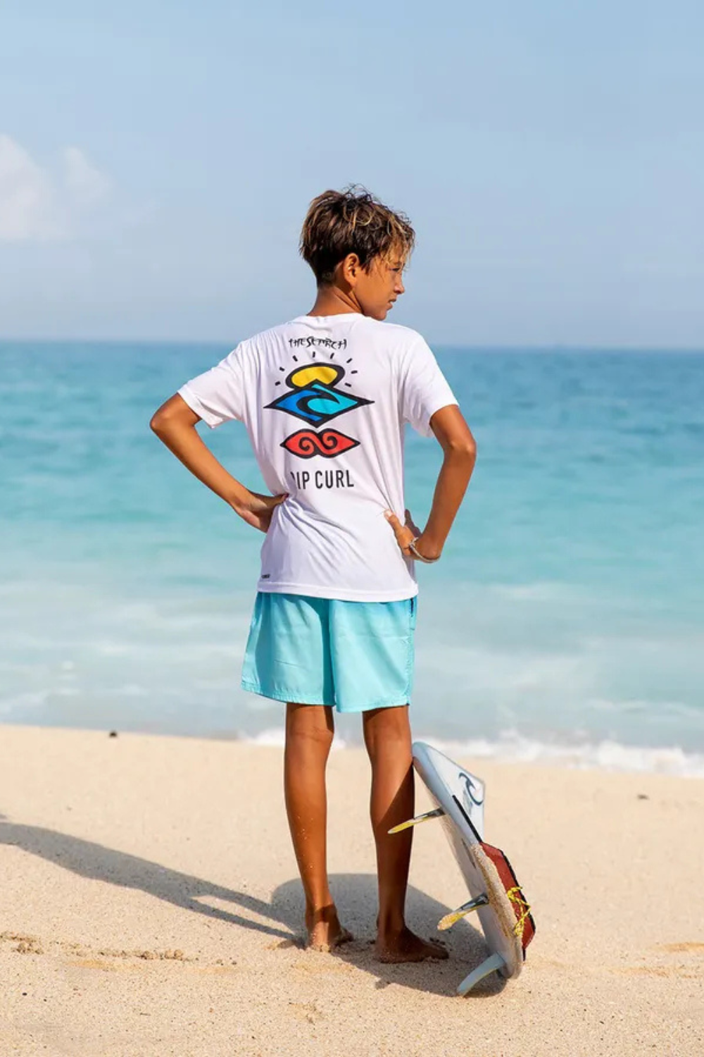 T-shirt anti-UV blanc UPF 50+ pour garçon, parfait pour jouer sur la plage avec une planche de surf.