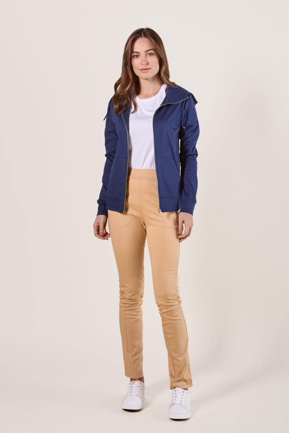 Femme portant un pantalon anti-UV beige UPF 50+ et une veste légère, look décontracté idéal pour l'extérieur.