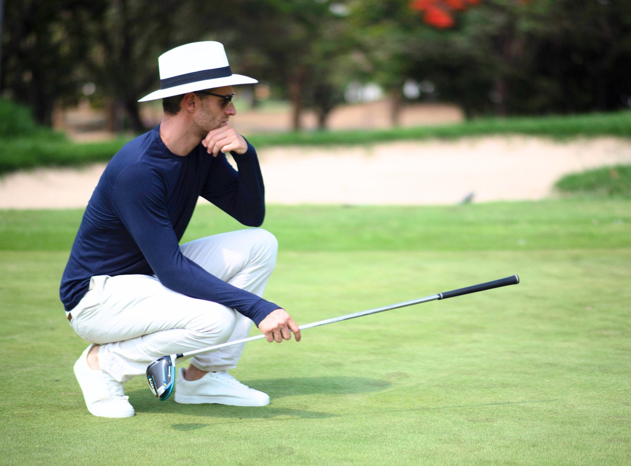 Homme jouant au golf et portant un chapeau et un polo anti-UV